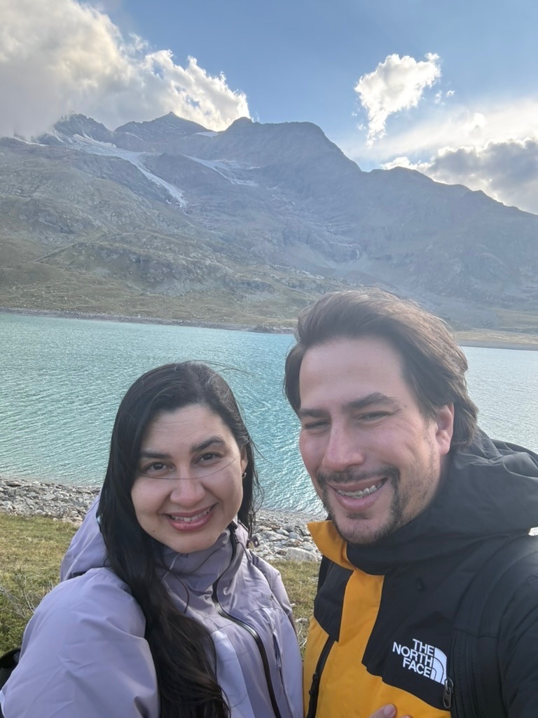 Bruno e Luciana sorrindo diante de um lago e montanhas