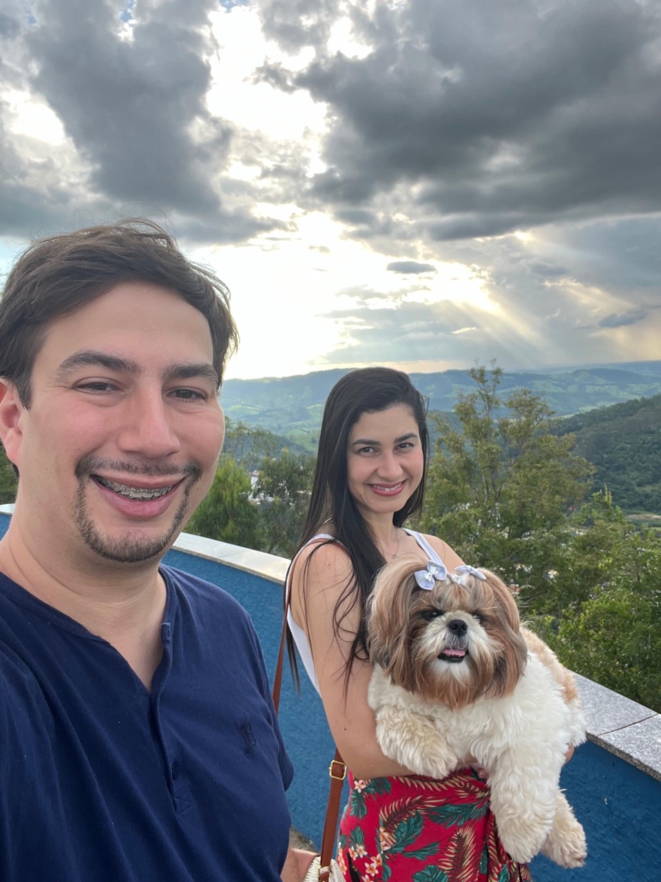 Bruno e Luciana com a Luninha diante das montanhas